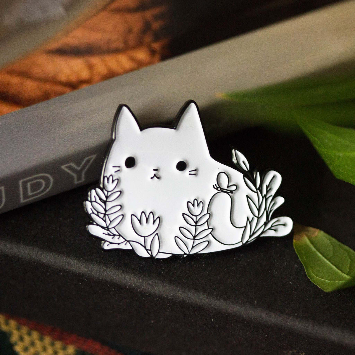 Cat laying in flowers with butterfly.