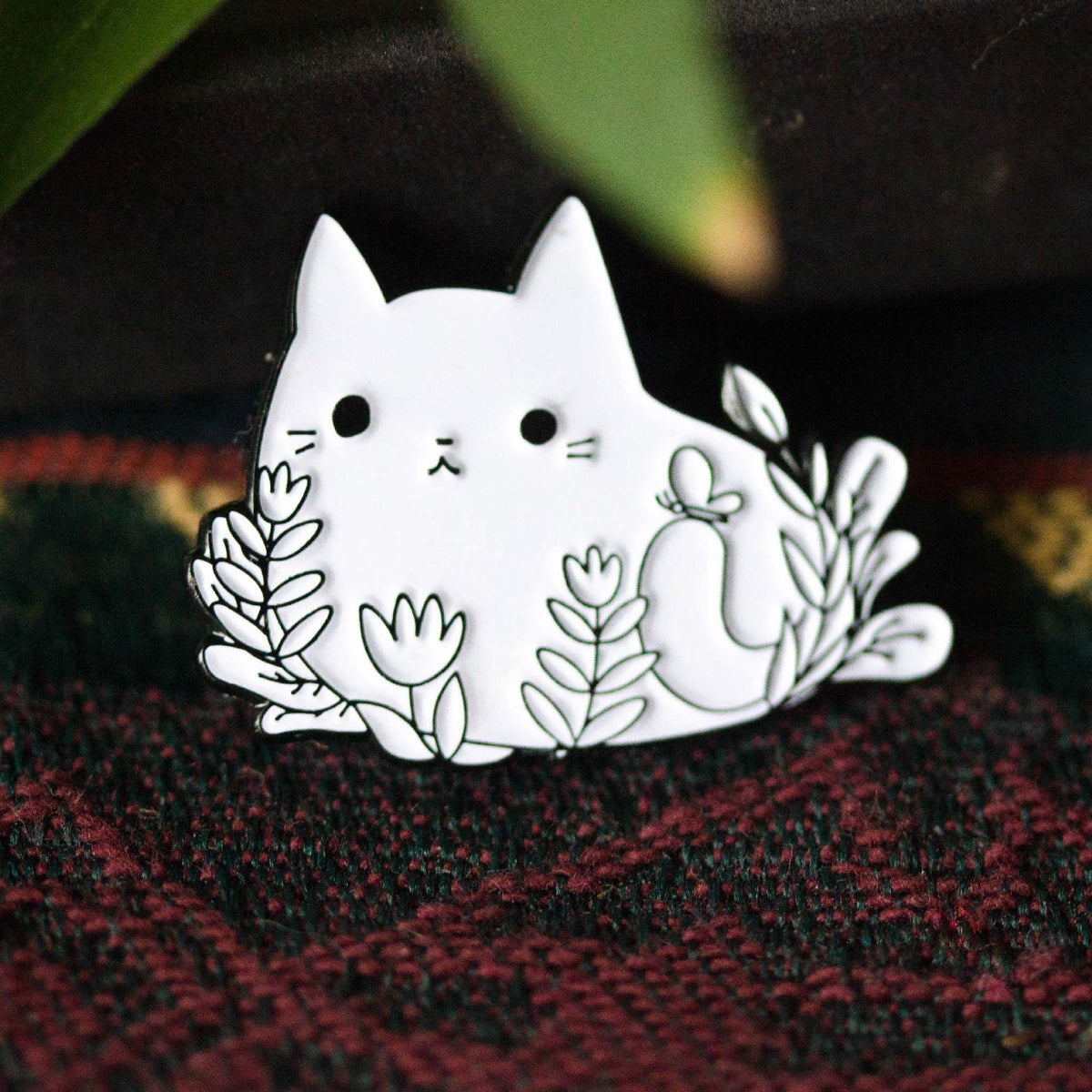 Cat laying in flowers with butterfly.